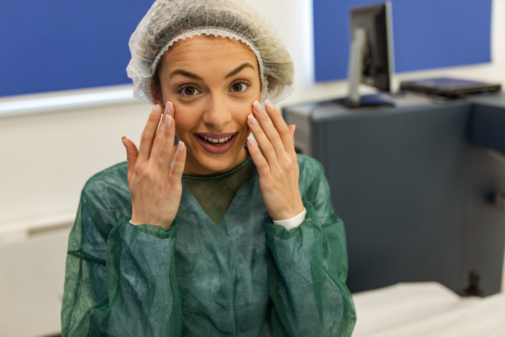 Woman smiling and holding up hands up to her eyes