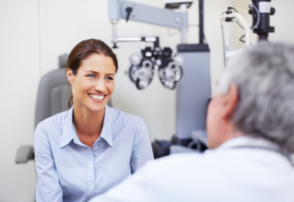 Woman smiling and talking to LASIK Eye Surgeon