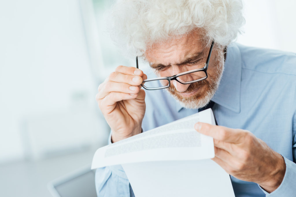 Older Man trying to read with Glasses on